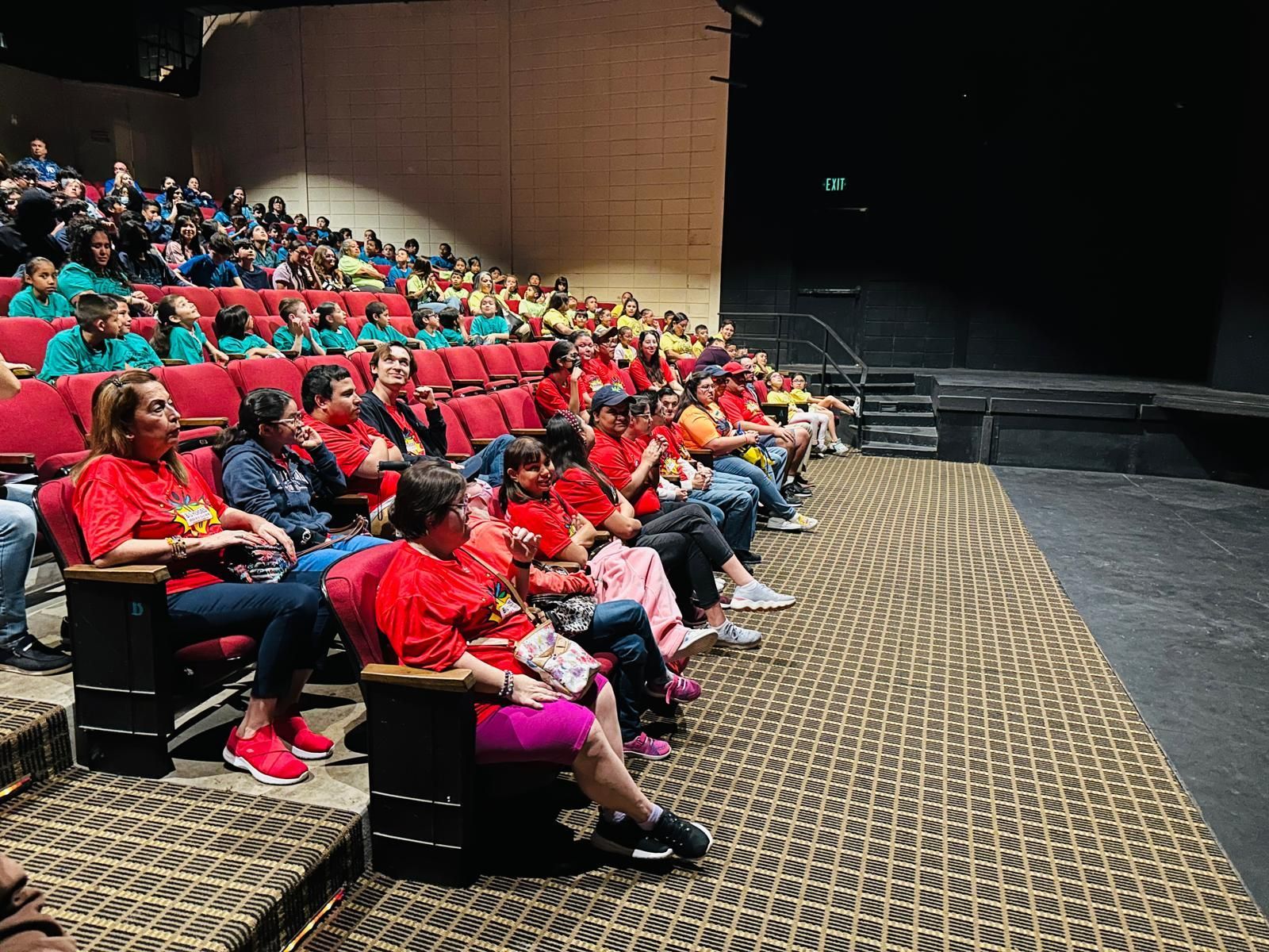 A large group of people are sitting in an auditorium.