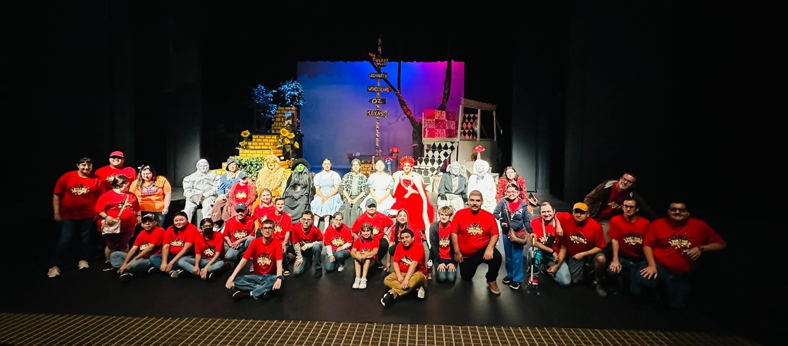 A large group of people are posing for a picture on a stage.