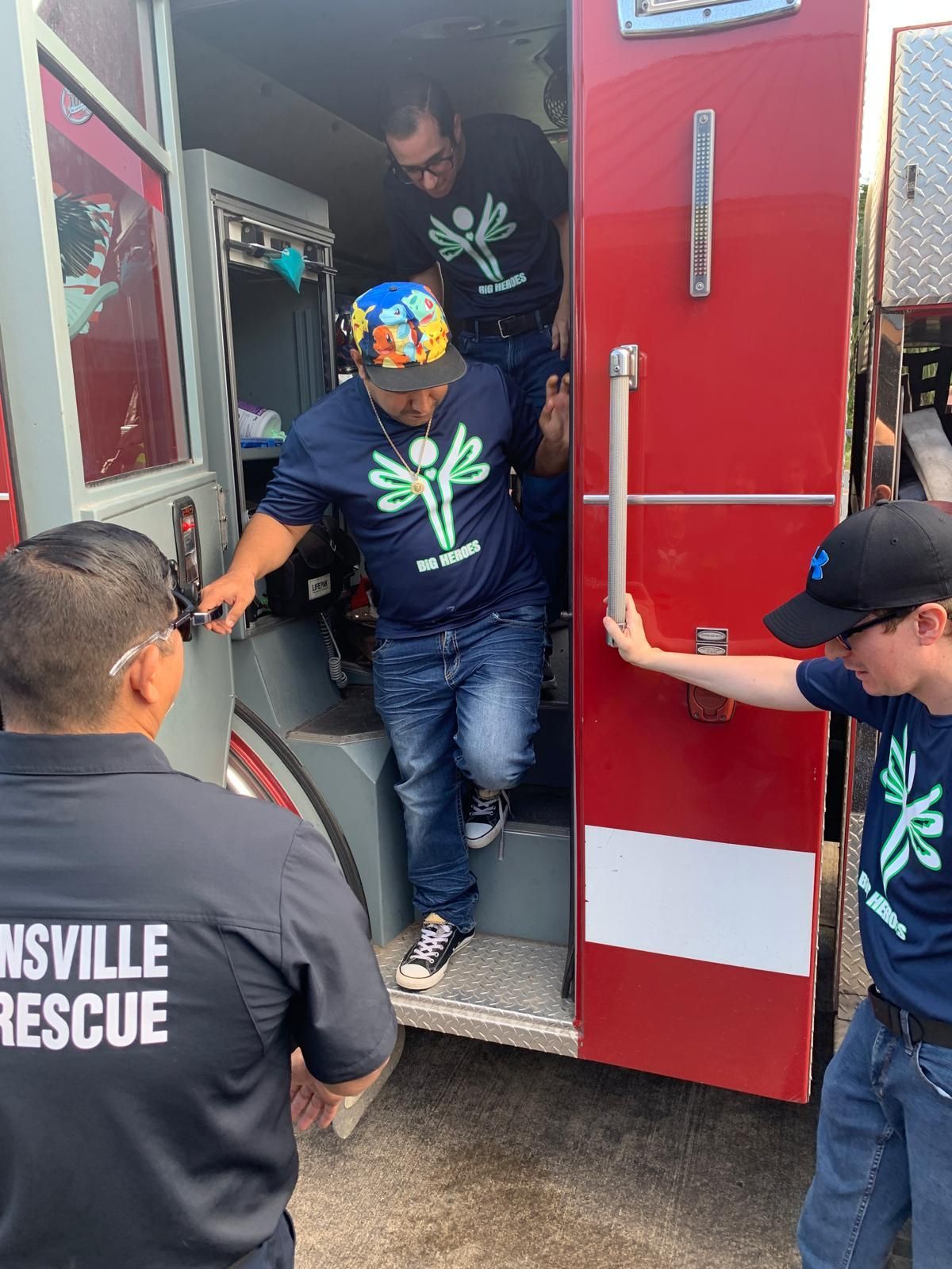 A group of men are getting out of an ambulance.