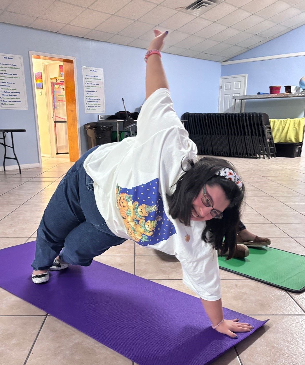 A woman is doing a yoga pose on a purple mat