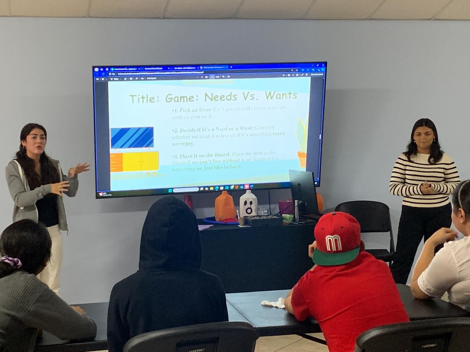 A woman is giving a presentation to a group of people in a classroom.