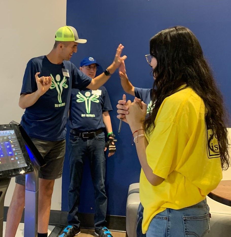 A woman in a yellow shirt is giving a man a high five