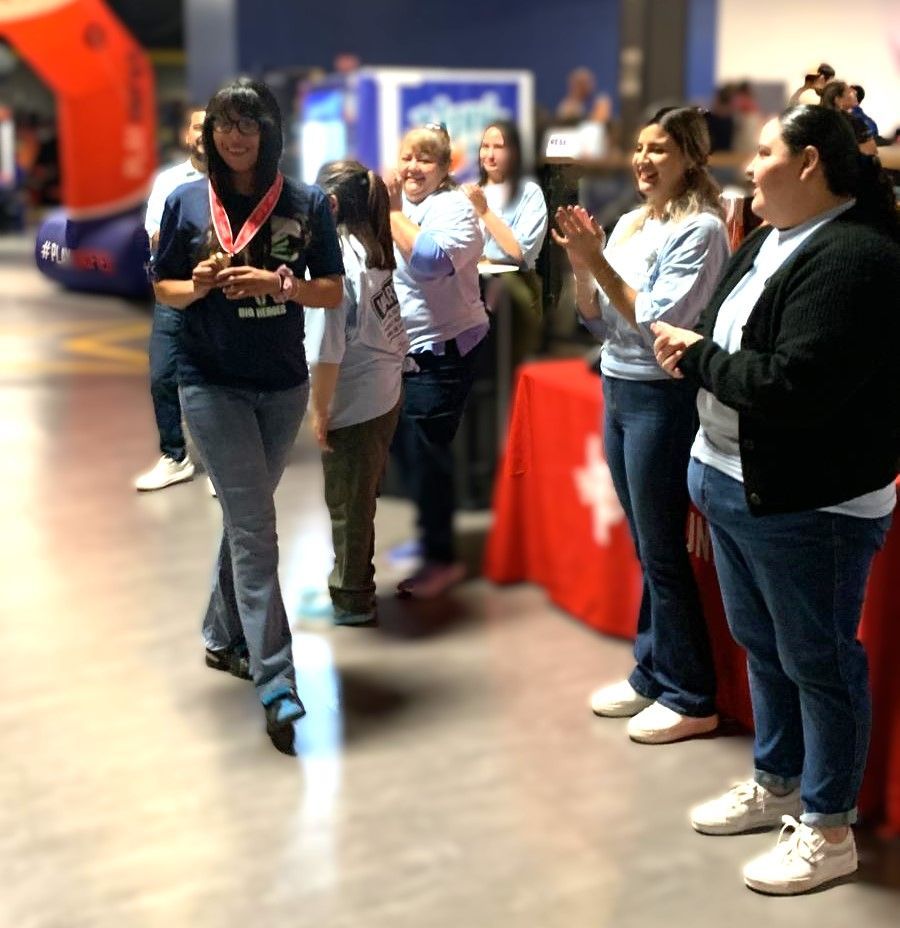 A group of people are standing in a hallway applauding