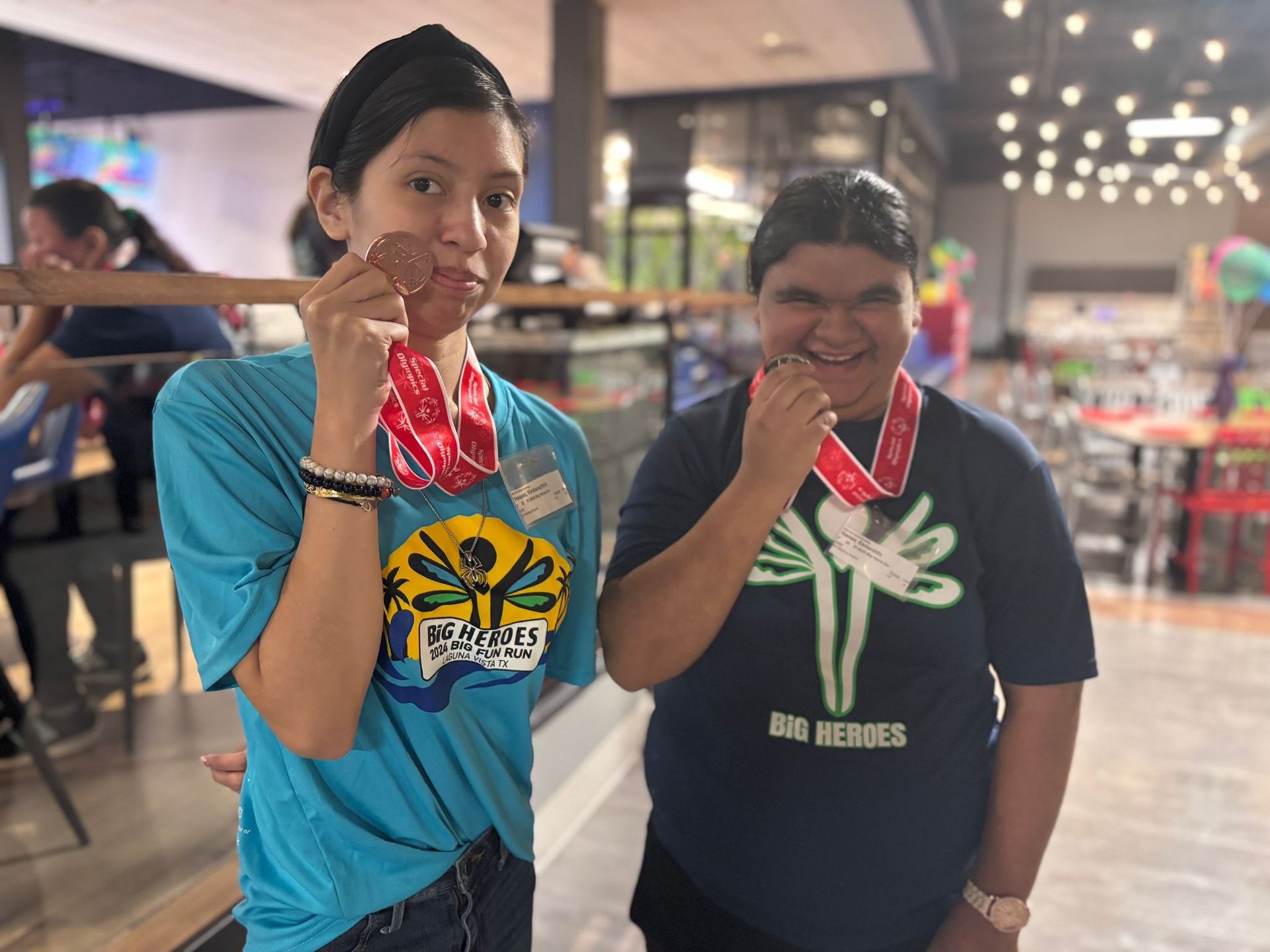 A boy and a girl are posing for a picture with medals around their necks.