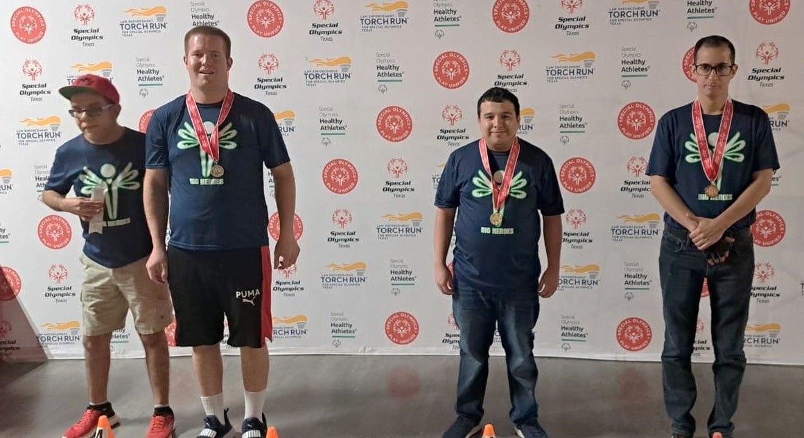 A group of men wearing medals are standing in front of a wall.