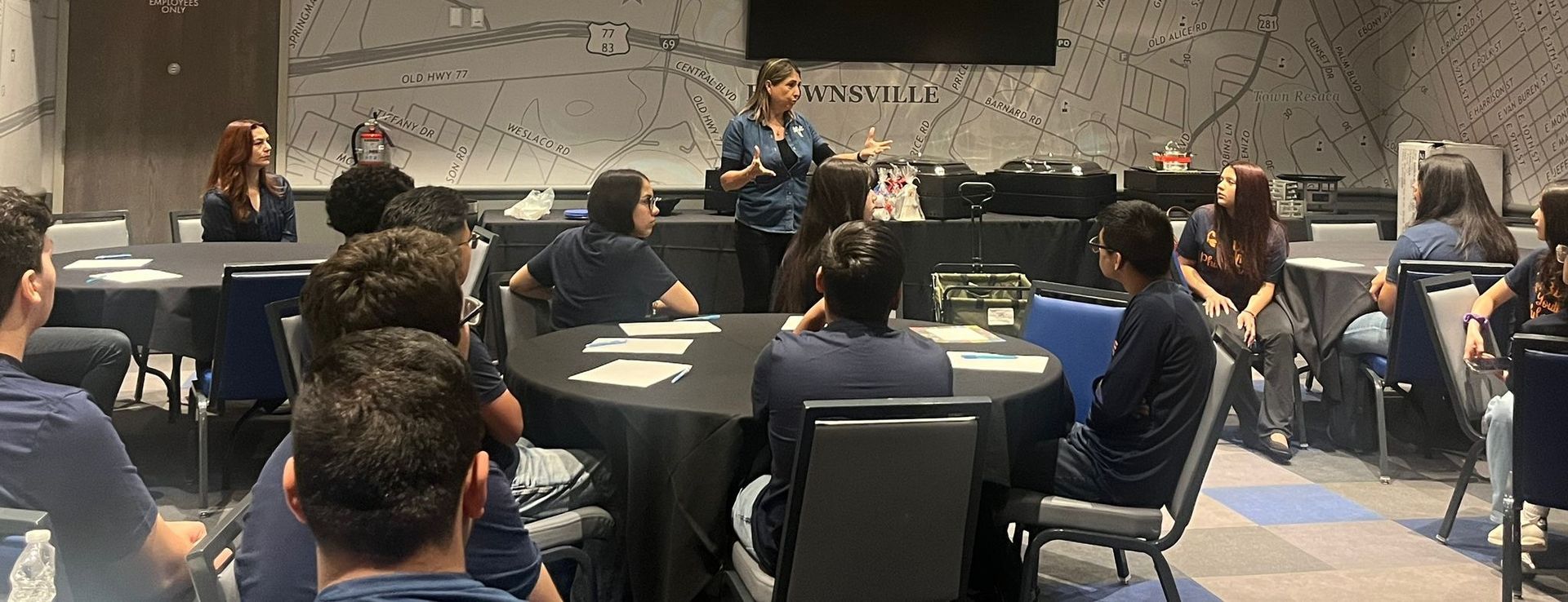 A woman is giving a presentation to a group of people in a conference room.