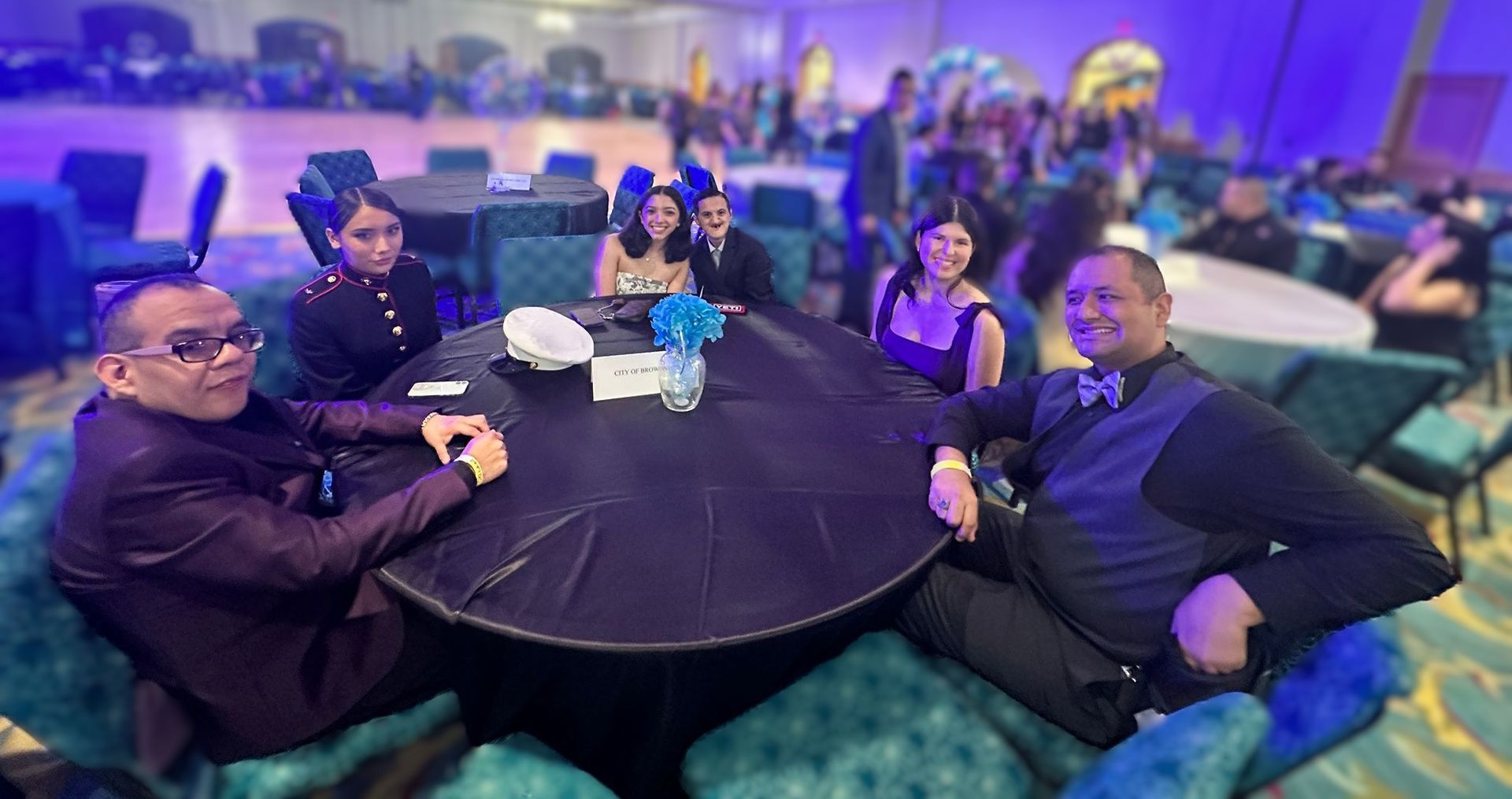 A group of people are sitting around a table in a room.