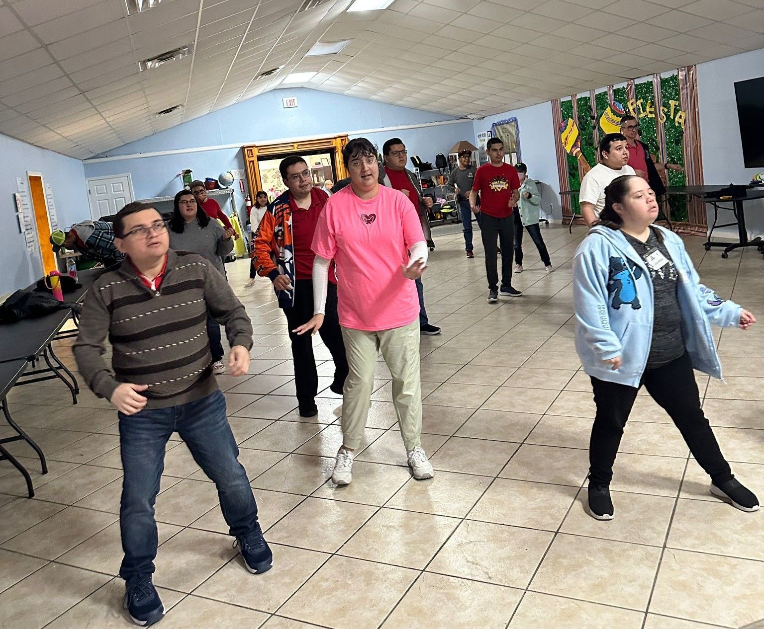 A group of people are dancing in a room.