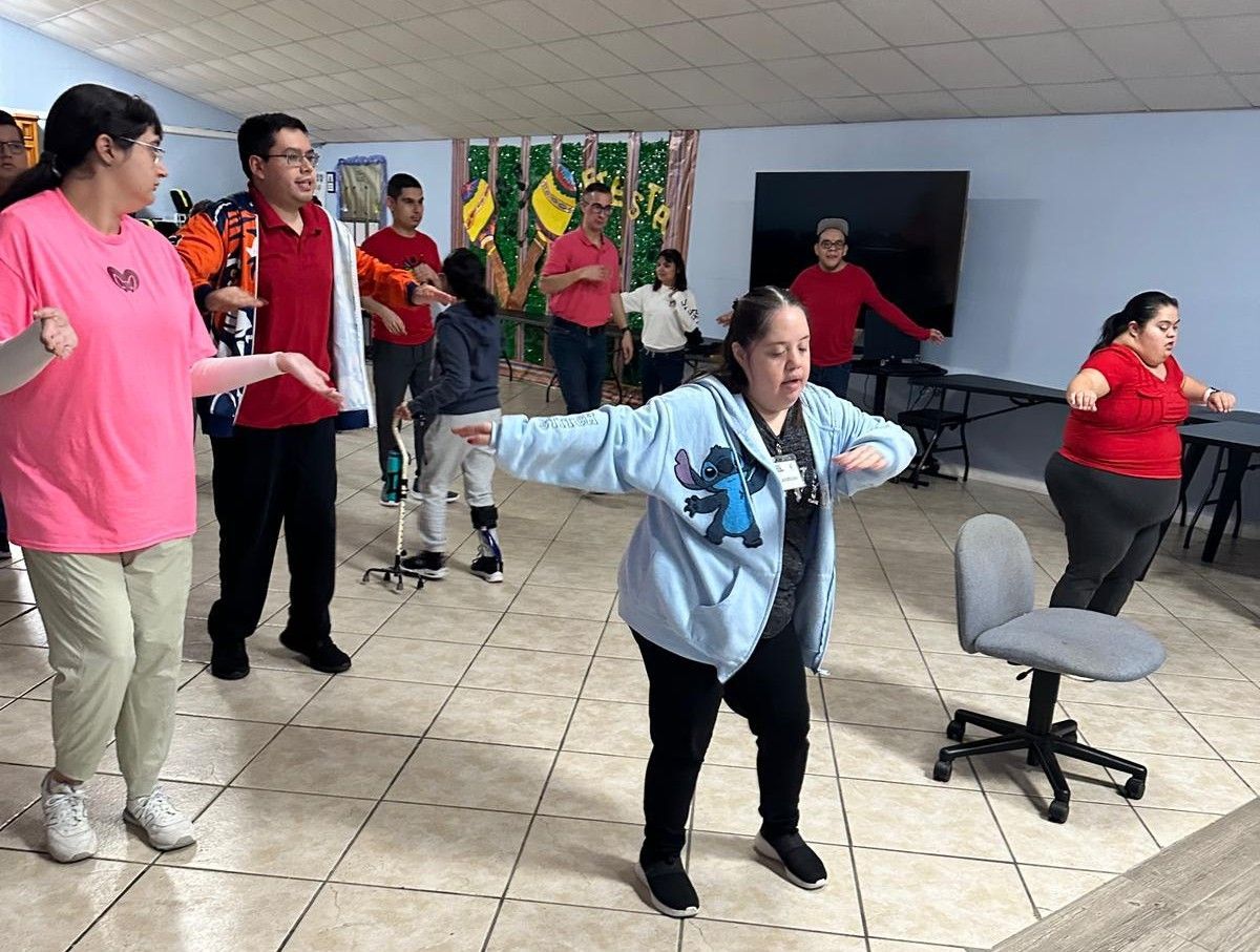 A group of people are dancing together in a room