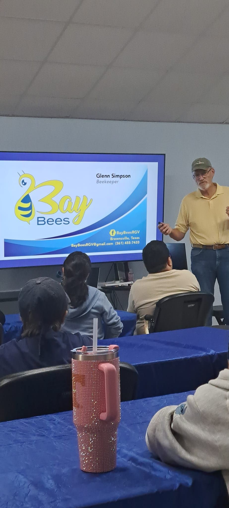 A man is giving a presentation to a group of people in a classroom.