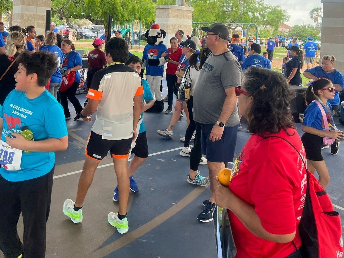 A woman in a red shirt is standing in a crowd of people