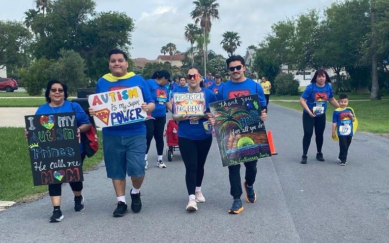 A group of people are walking down a street holding signs.