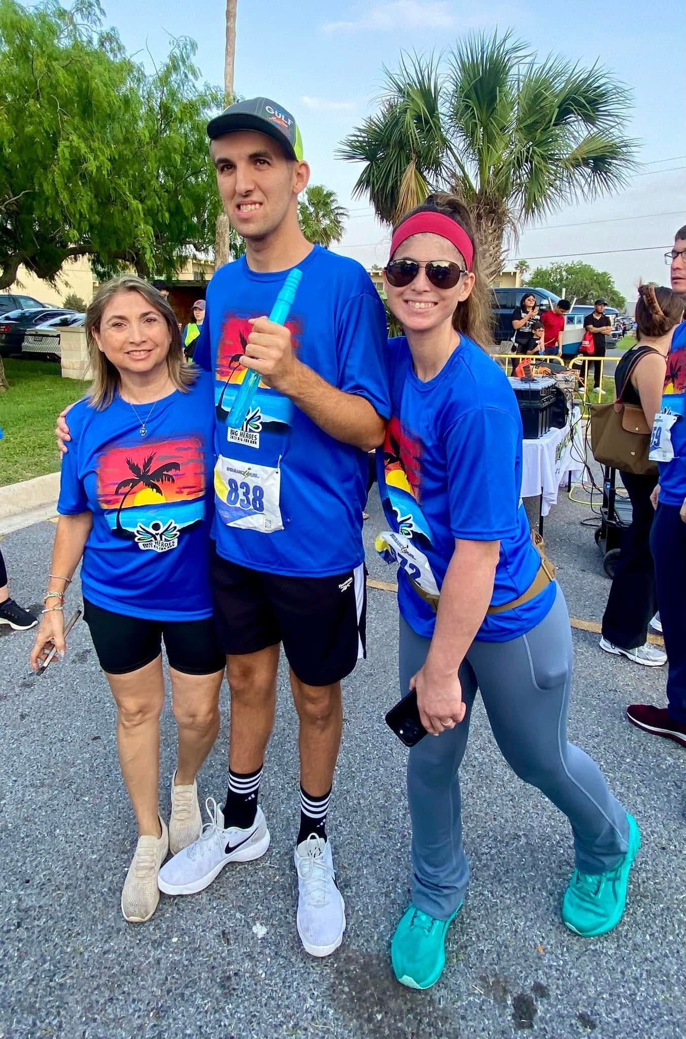 A group of people wearing blue shirts are posing for a picture.