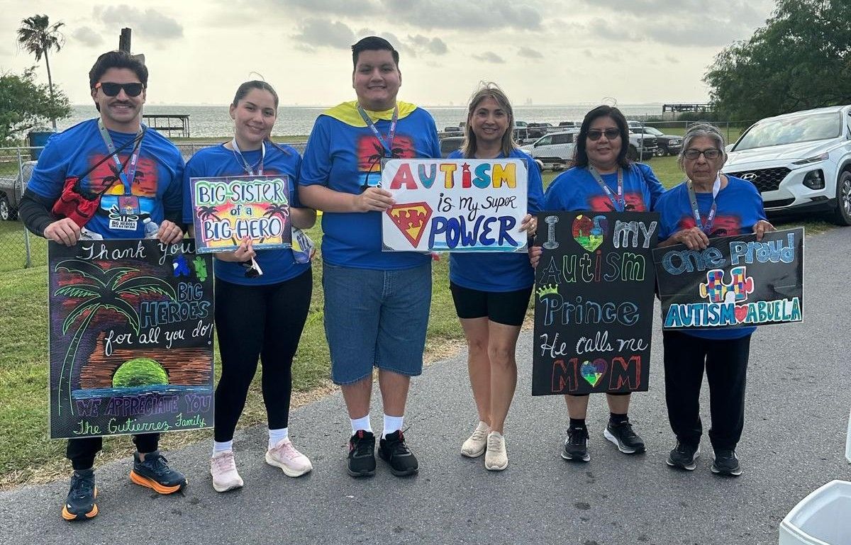 A group of people standing next to each other holding signs.
