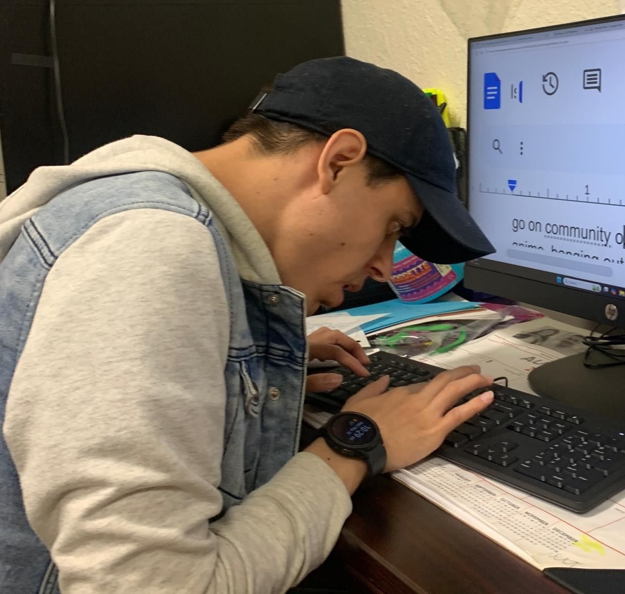 A man is typing on a keyboard in front of a computer screen that says go on community