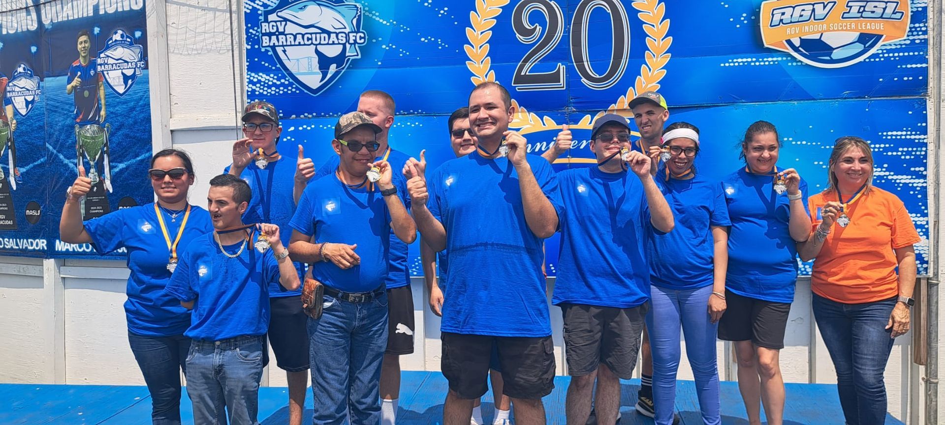 A group of people in blue shirts are posing for a picture.