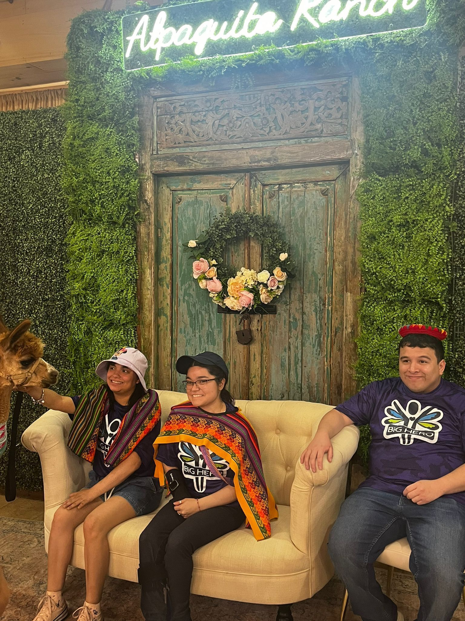 Three people on a couch pose at