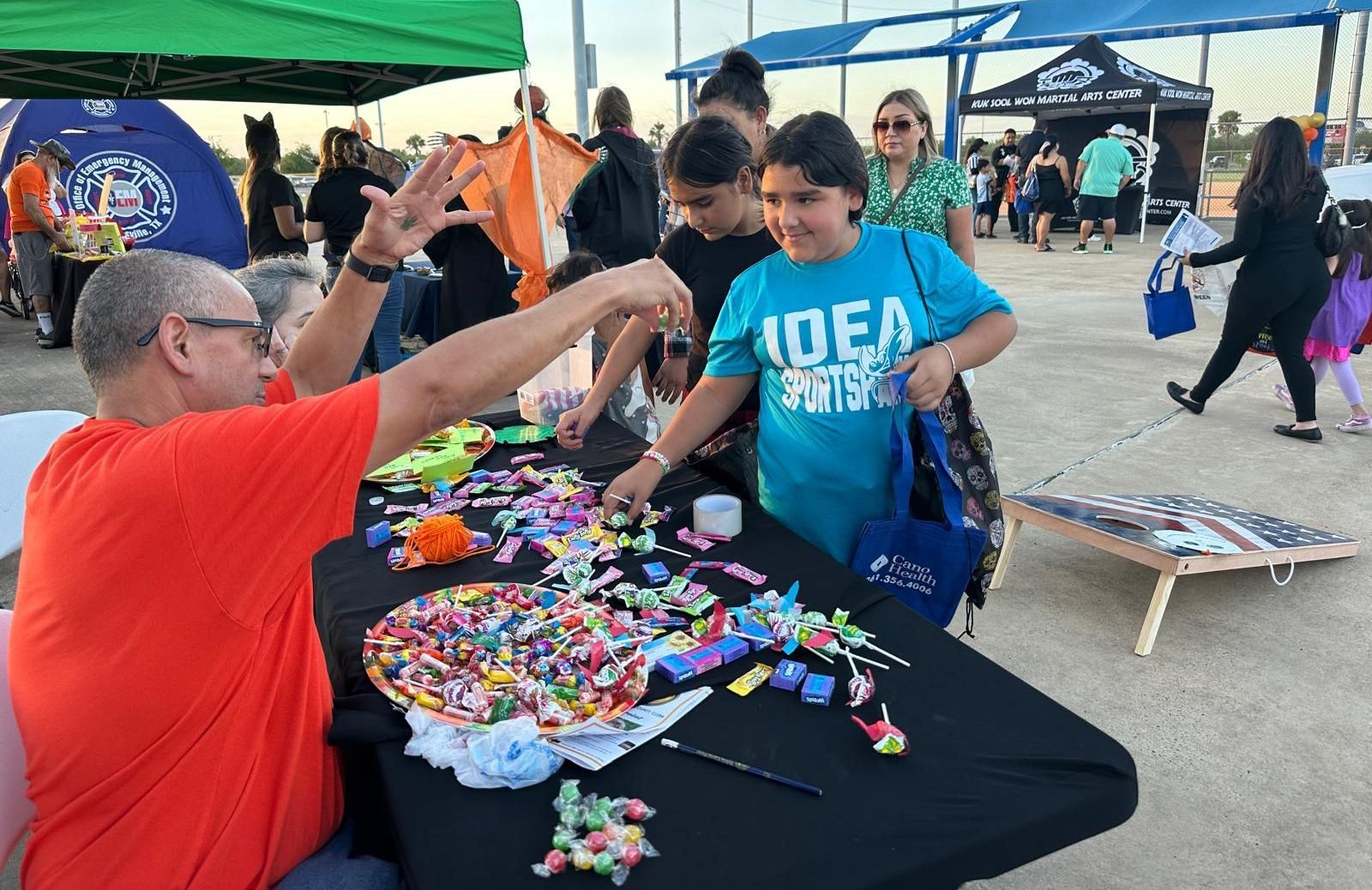 A group of people are standing around a table looking at toys.