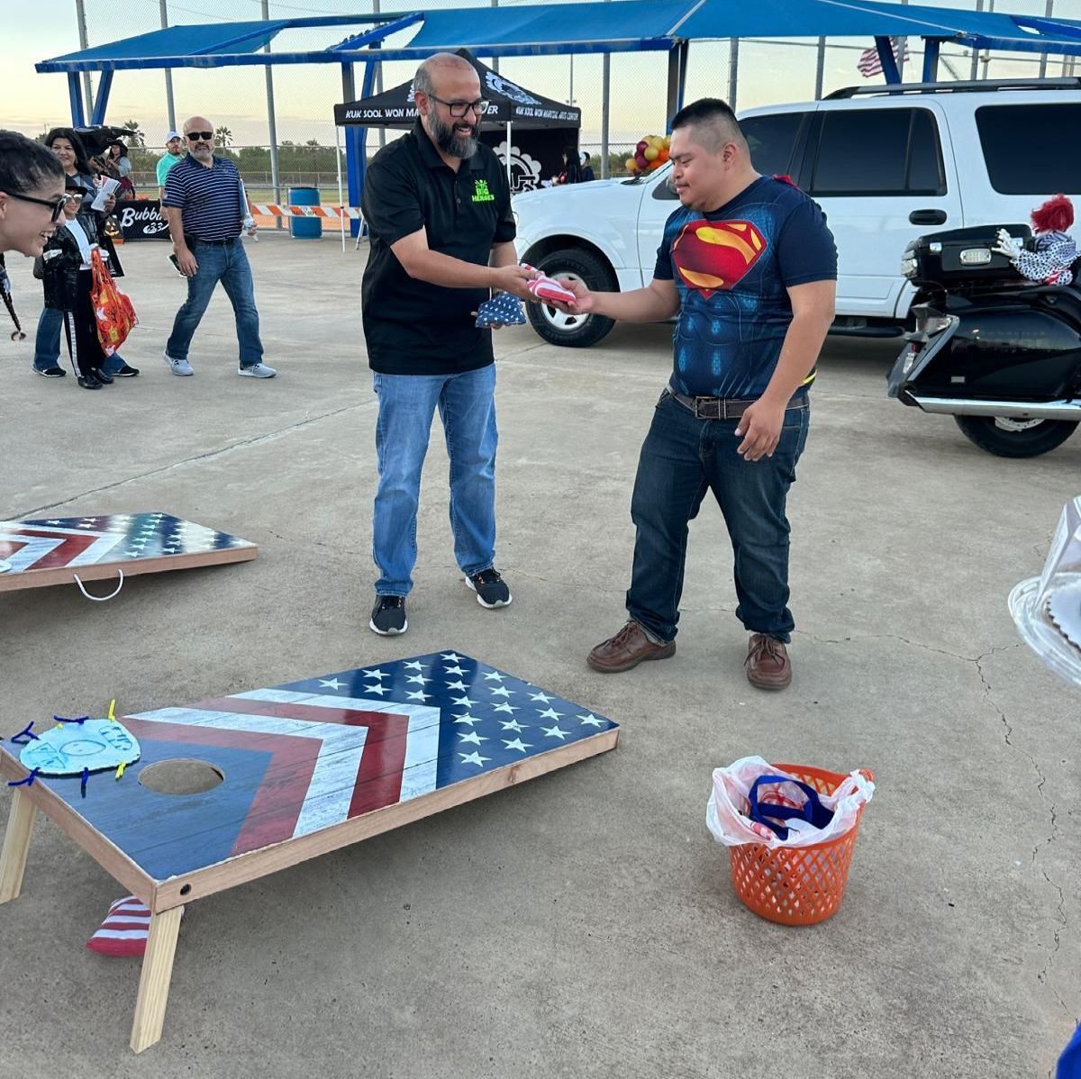 A man in a superman shirt is shaking hands with another man
