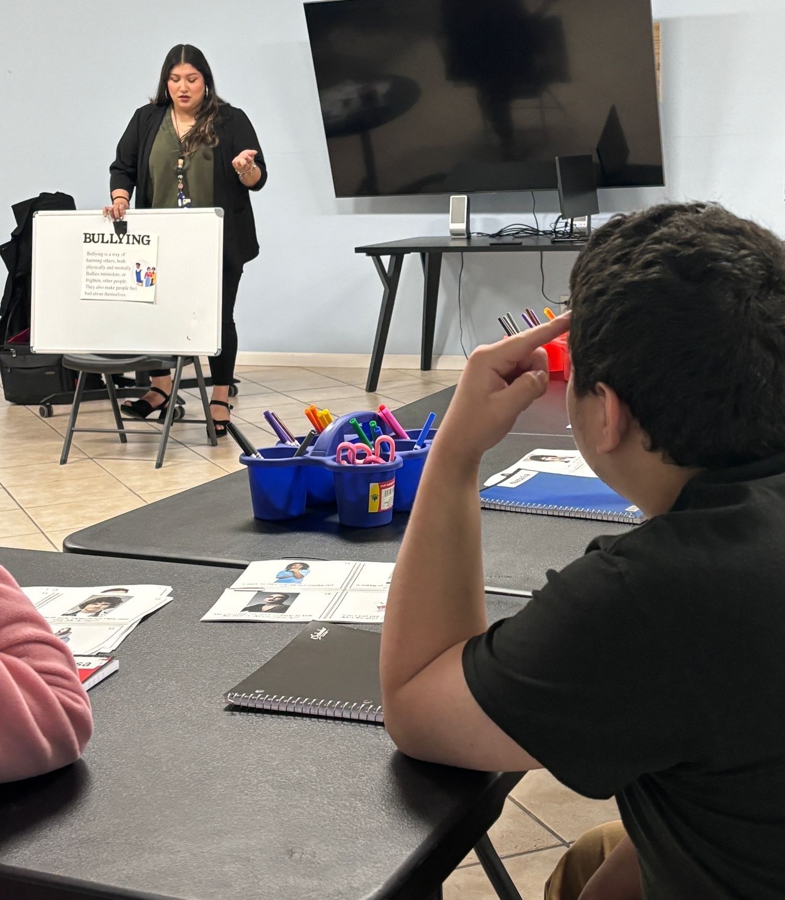 A woman is giving a presentation to a group of children