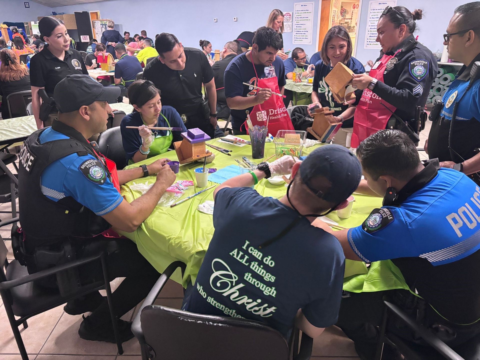 A group of people are sitting around a table with one man wearing a shirt that says chris