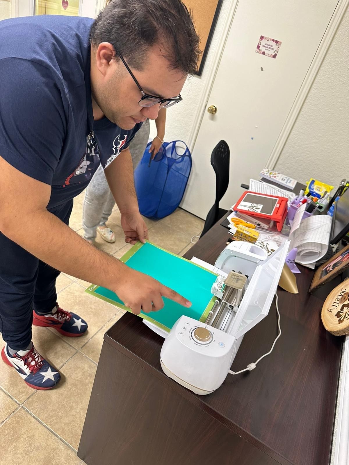 A man is using a machine to cut a piece of paper.