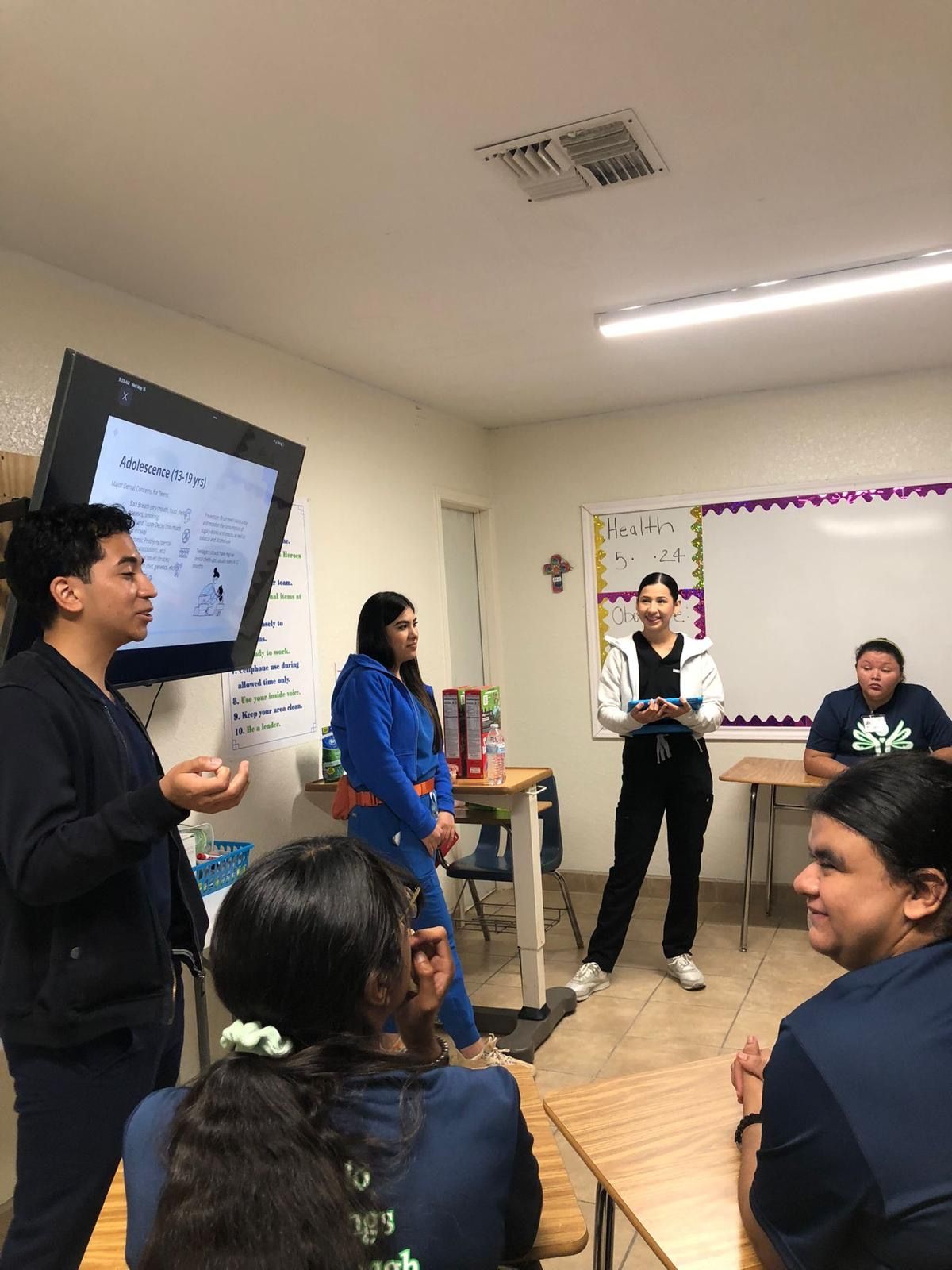A man is giving a presentation to a group of students in a classroom.