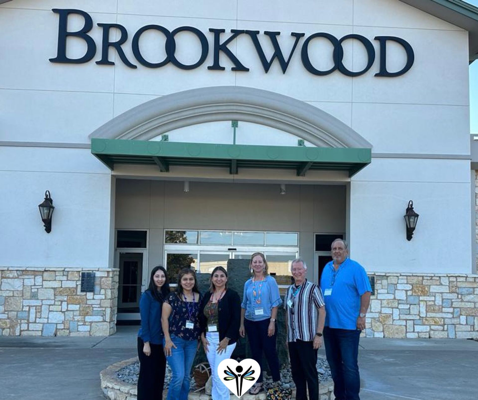 A group of people standing in front of a brookwood building