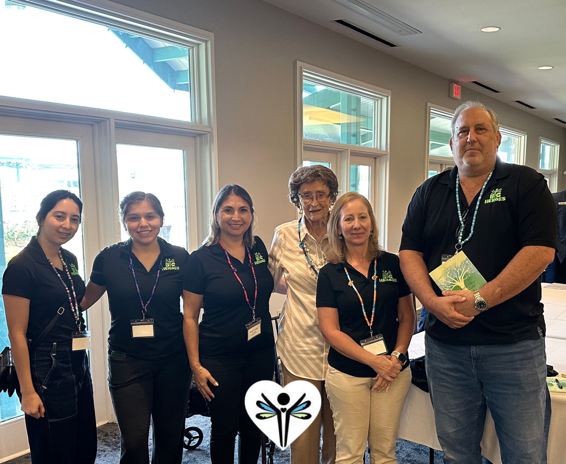 A group of people are posing for a picture in front of a window.