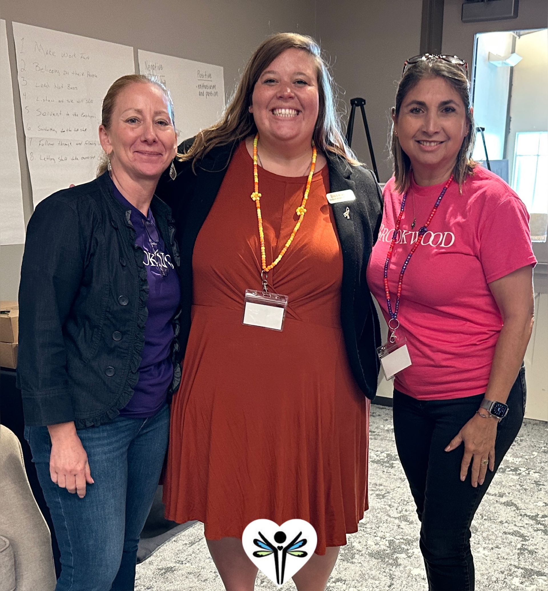 Three women are posing for a picture together in a room.