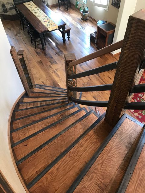 A spiral staircase with wooden steps and a metal railing in a living room.