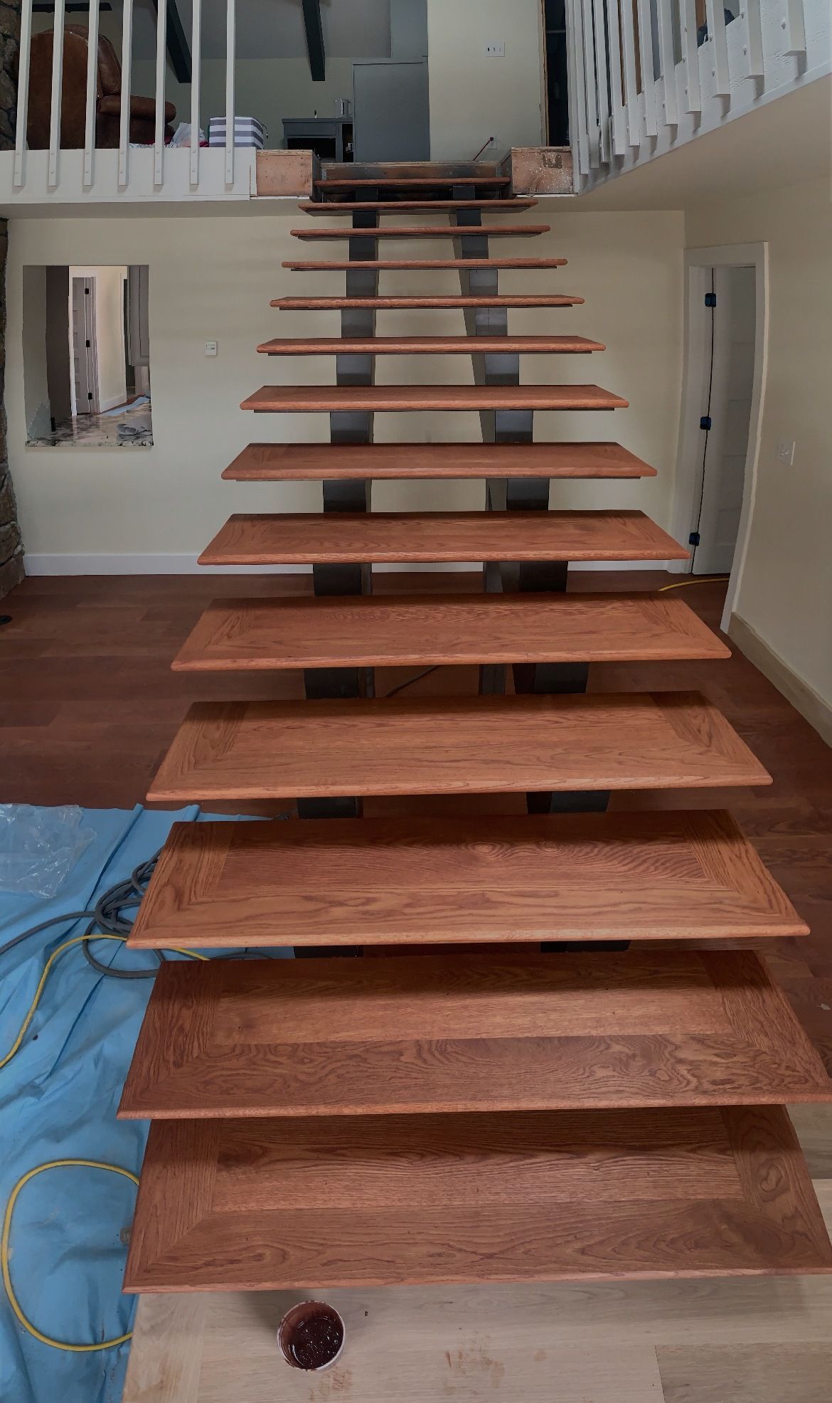 A wooden staircase is being built in a house.