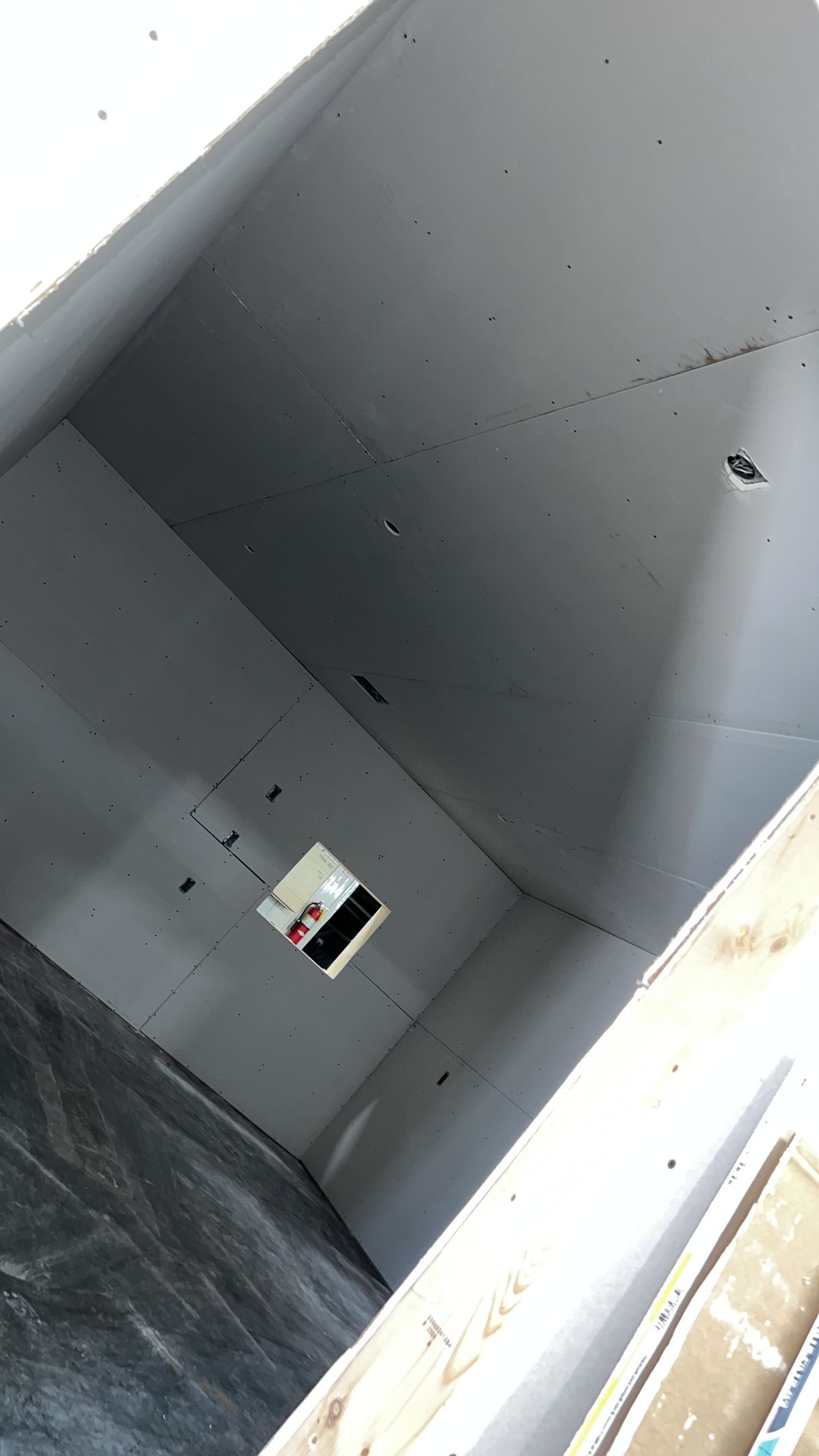 A man is working on a wall in a room.