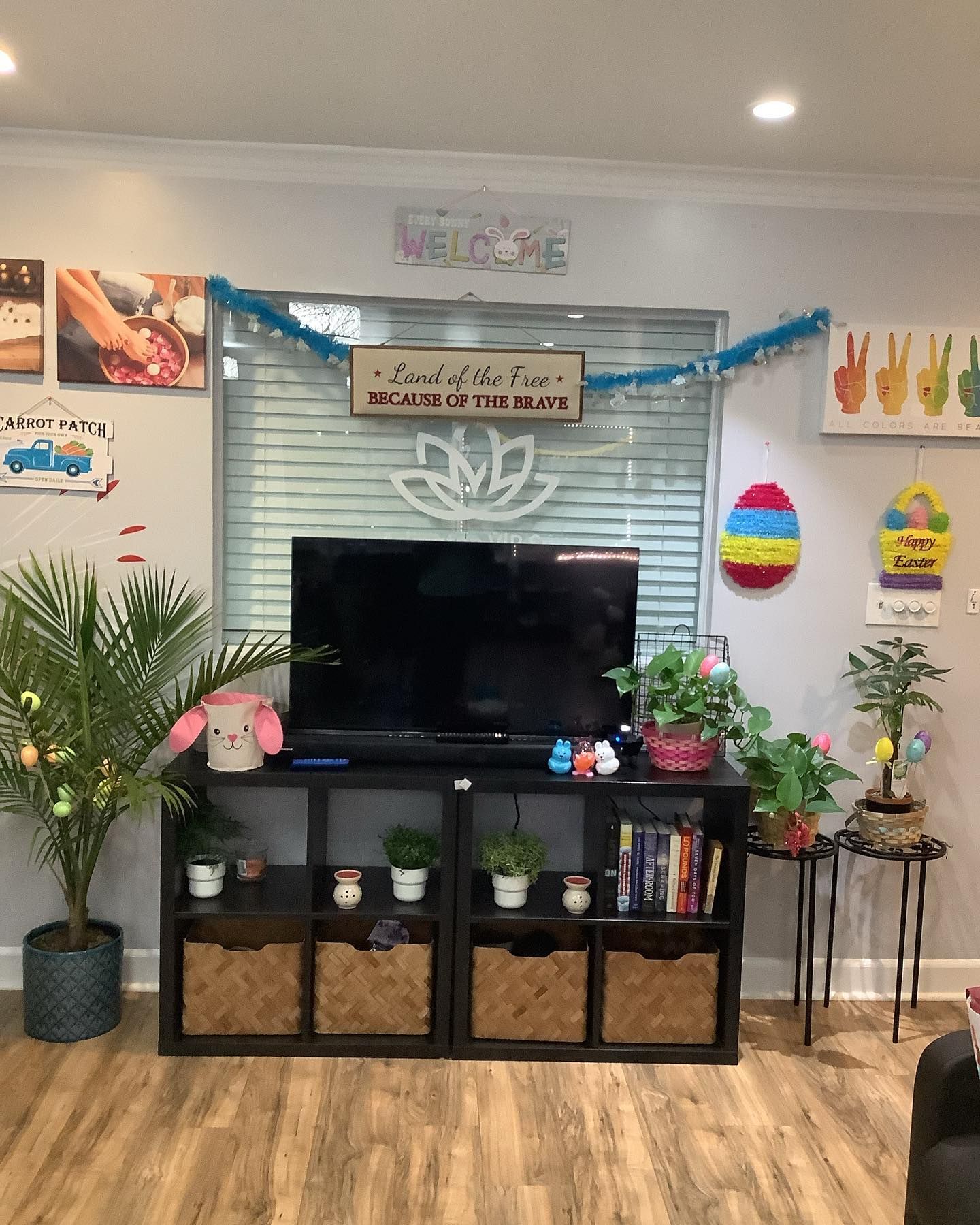 Living room with decorated TV stand and Easter decor, including eggs and plants.
