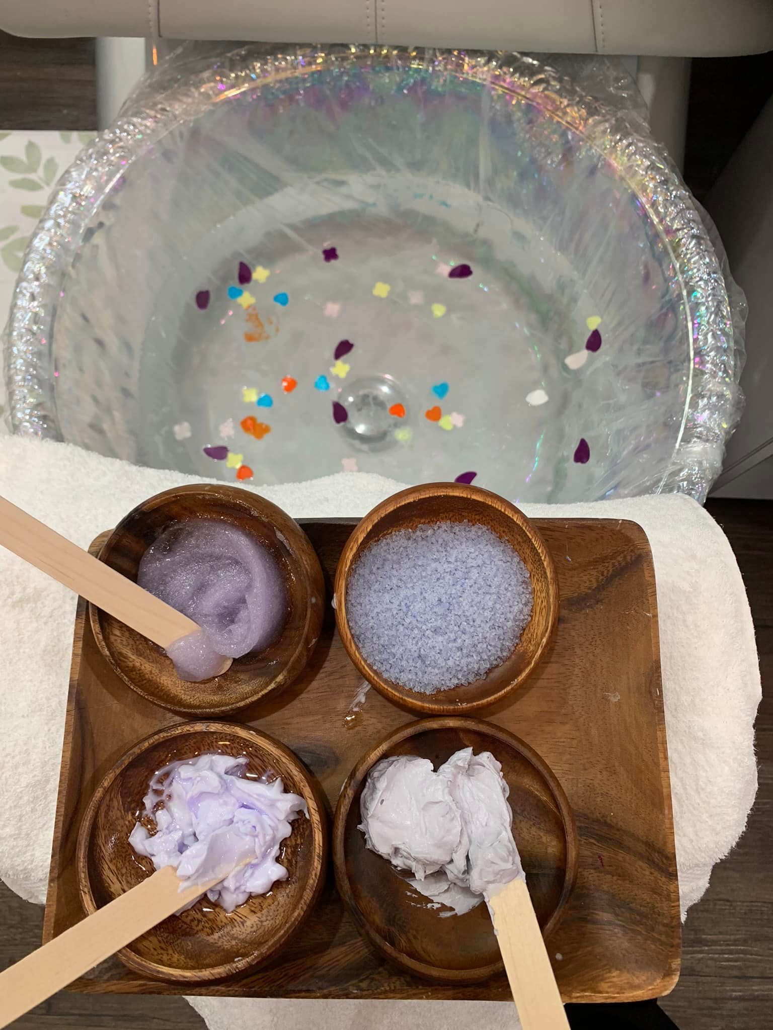 Foot spa setup with bowls of colorful scrubs and a foot bath.