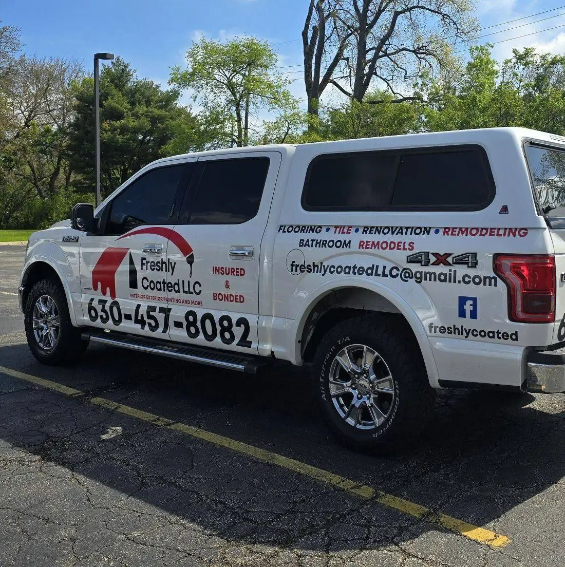 White pickup truck with company logo parked outside; advertising home renovations.