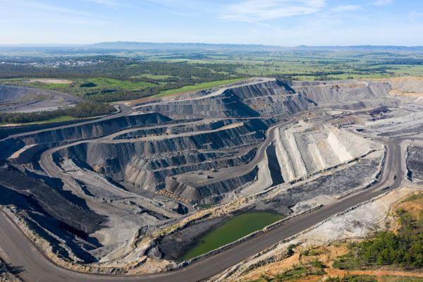 An aerial view of a large coal mine surrounded by trees and fields.
