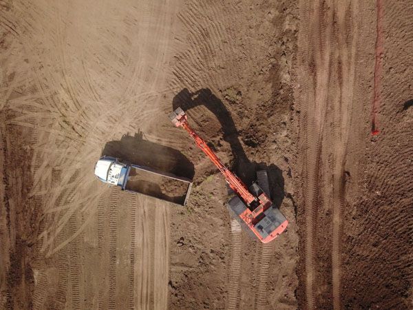 An aerial view of a bulldozer moving dirt on a construction site.