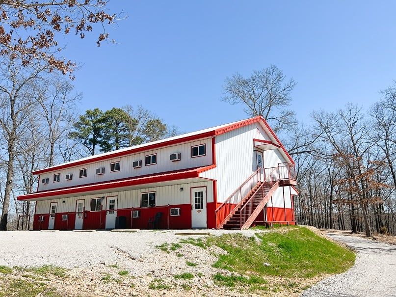 A large red and white motel with stairs leading up to it.
