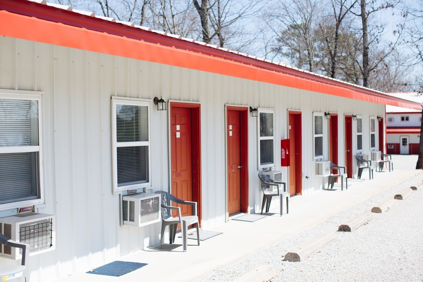 A white motel with red doors and a red roof