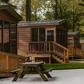 A wooden cabin with a picnic table in front of it.