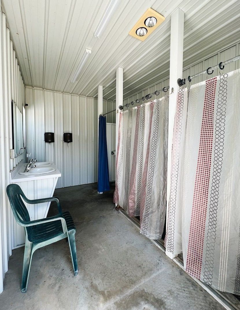 A bathroom with a sink , chair and shower curtains in the shower house.