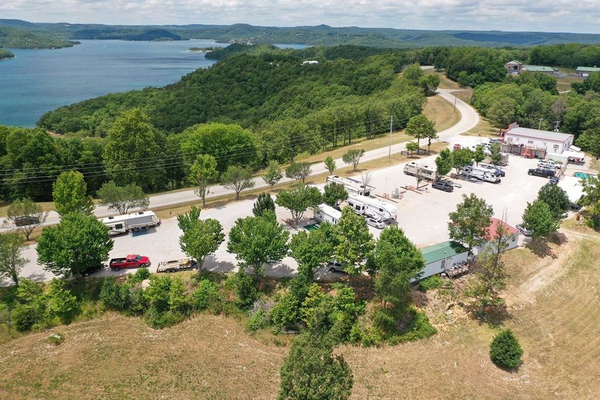 An aerial view of the RV park grounds next to Beaver Lake in the background.