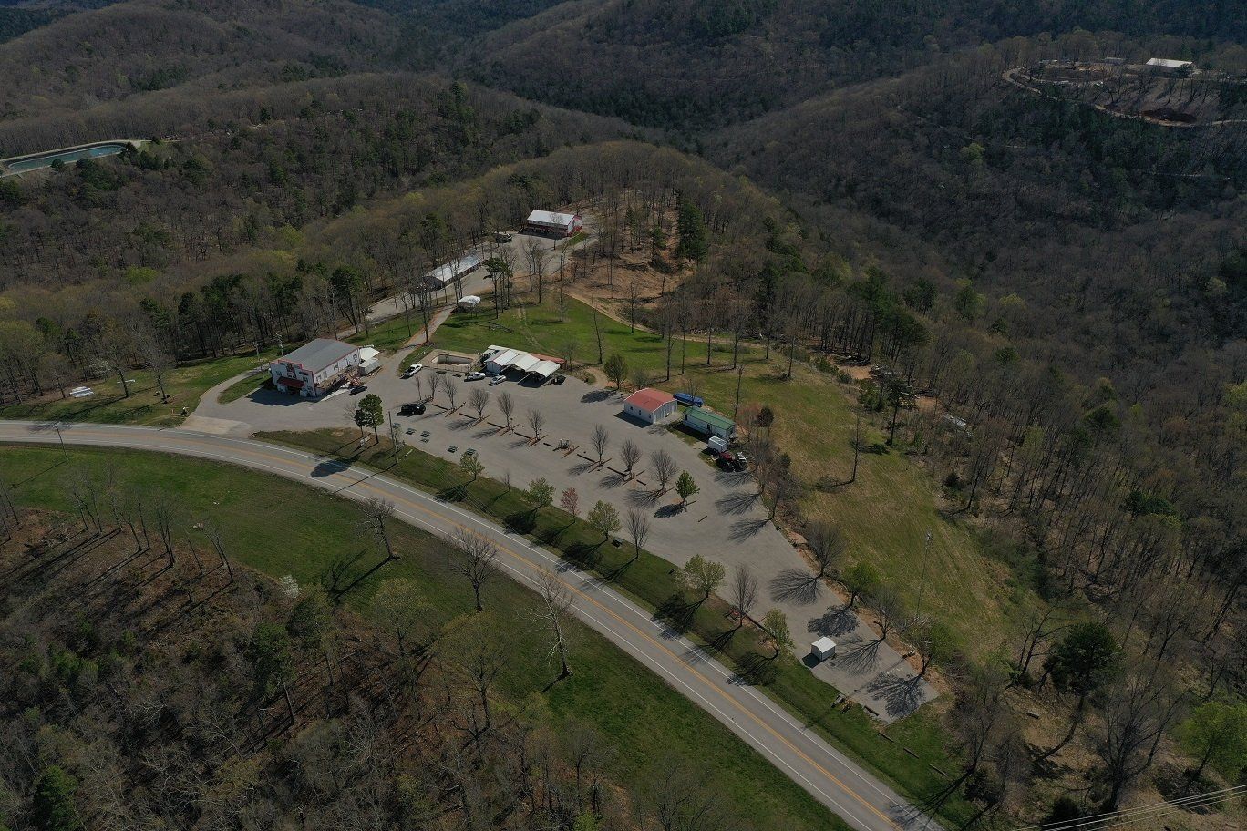 An aerial view of a parking lot on top of a hill surrounded by mountains.