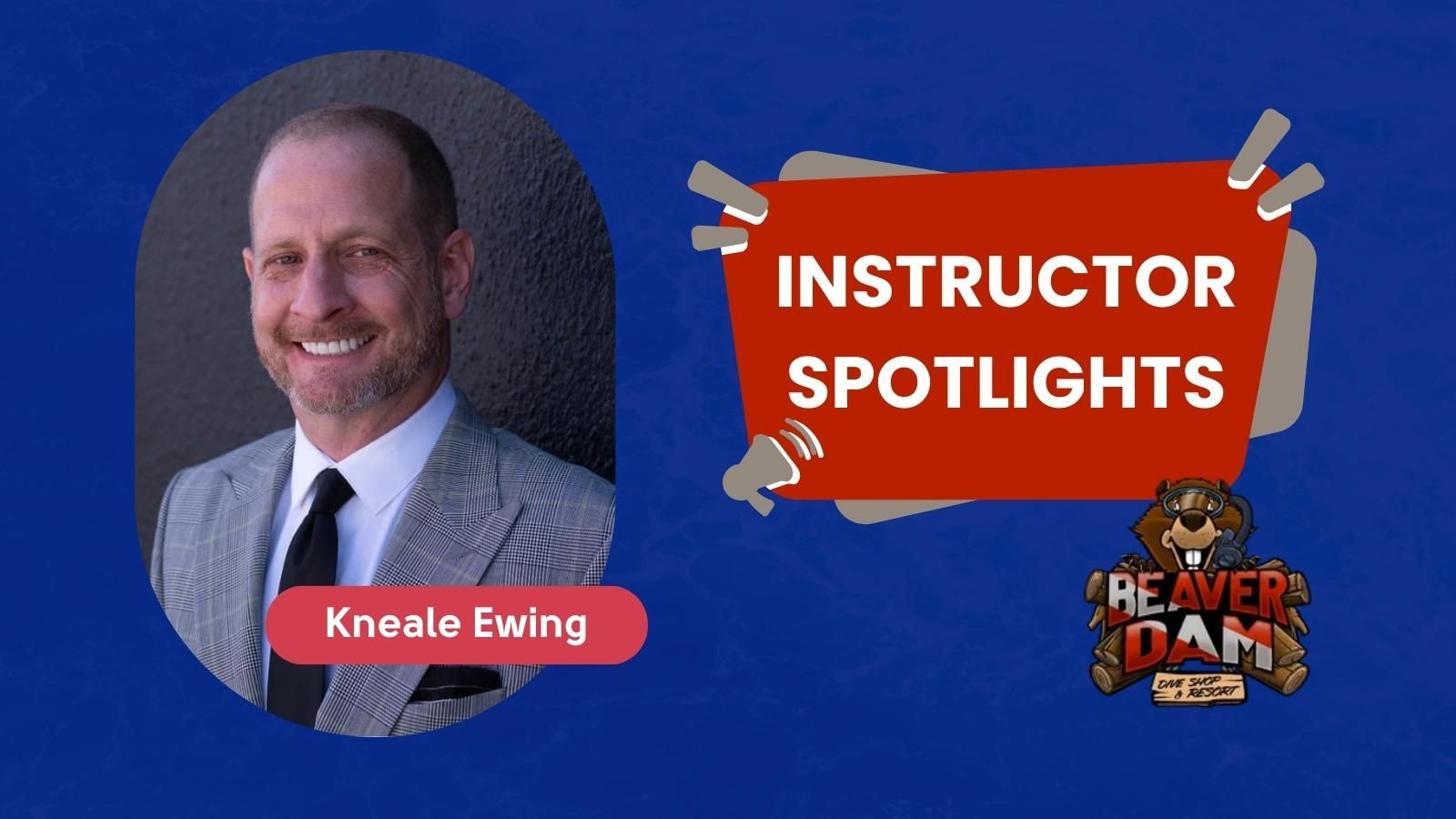 Kneale Ewing in a suit and tie is smiling in front of a black wall.