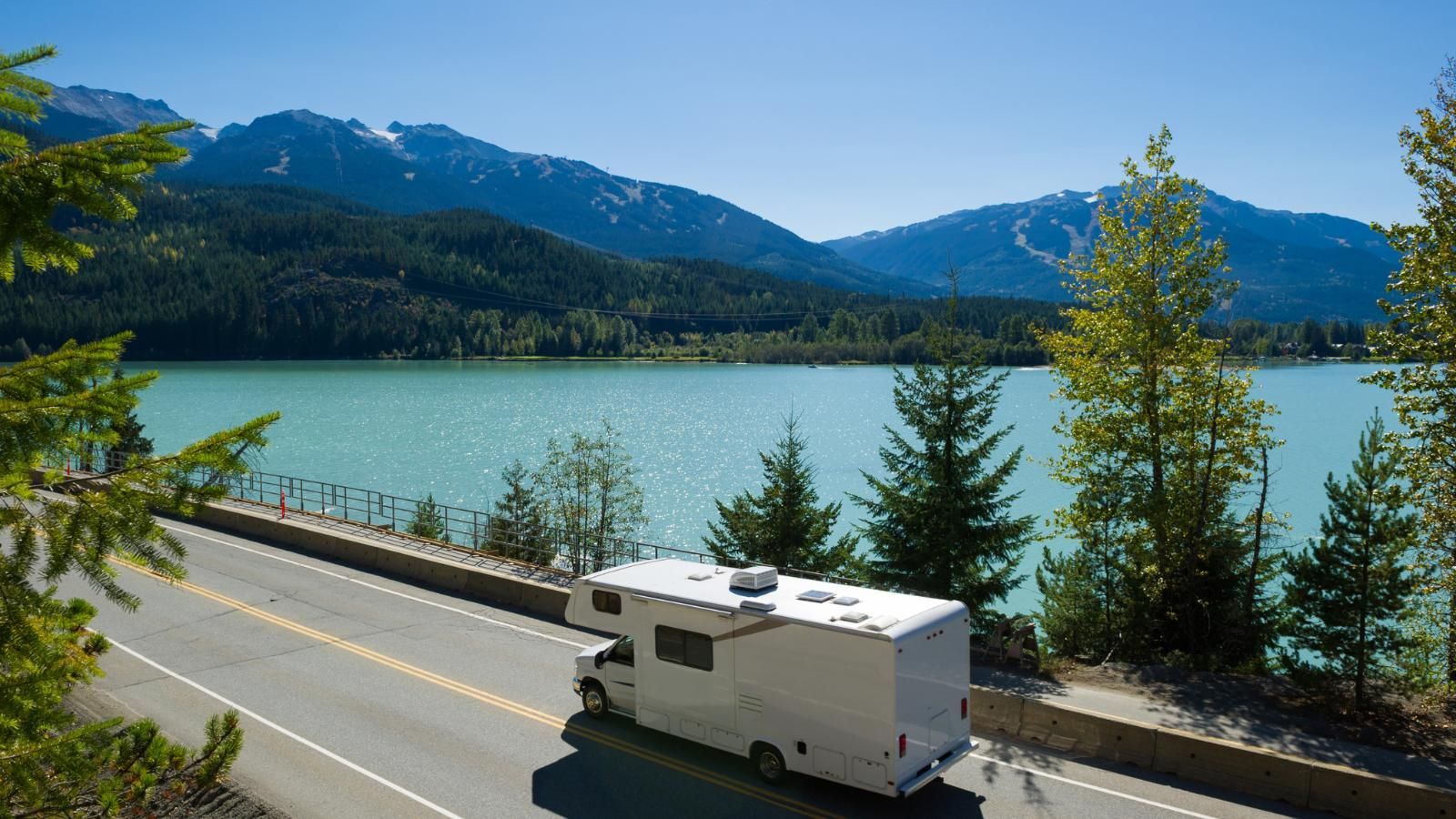 RV Camper traveling along a scenic lake road