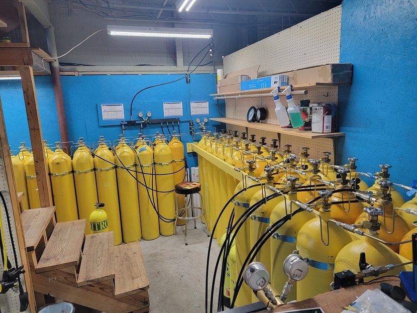 A room filled with lots of yellow scuba tanks.