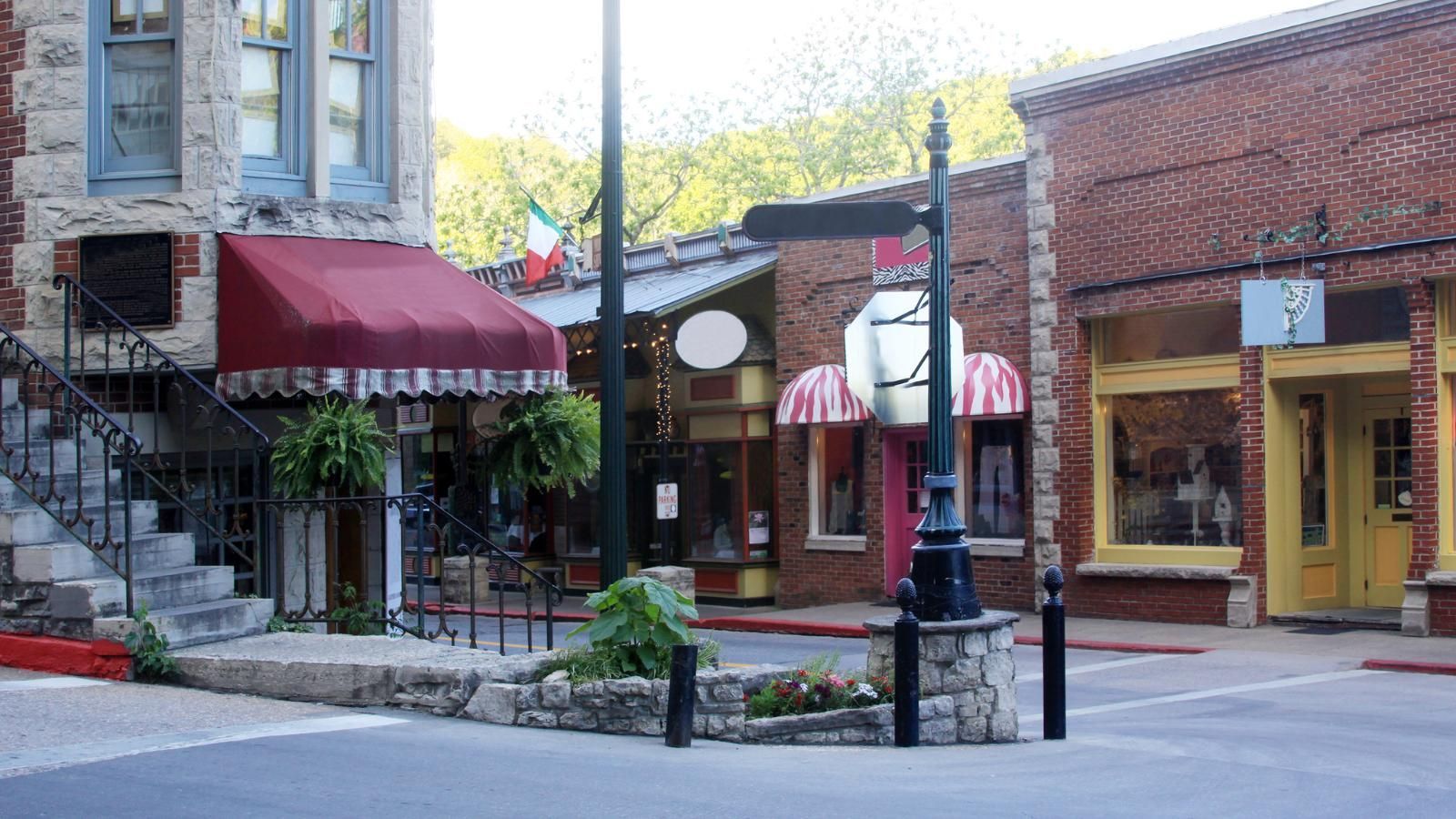 A brick building in historic downtown Eureka Springs with a red awning on the side of it