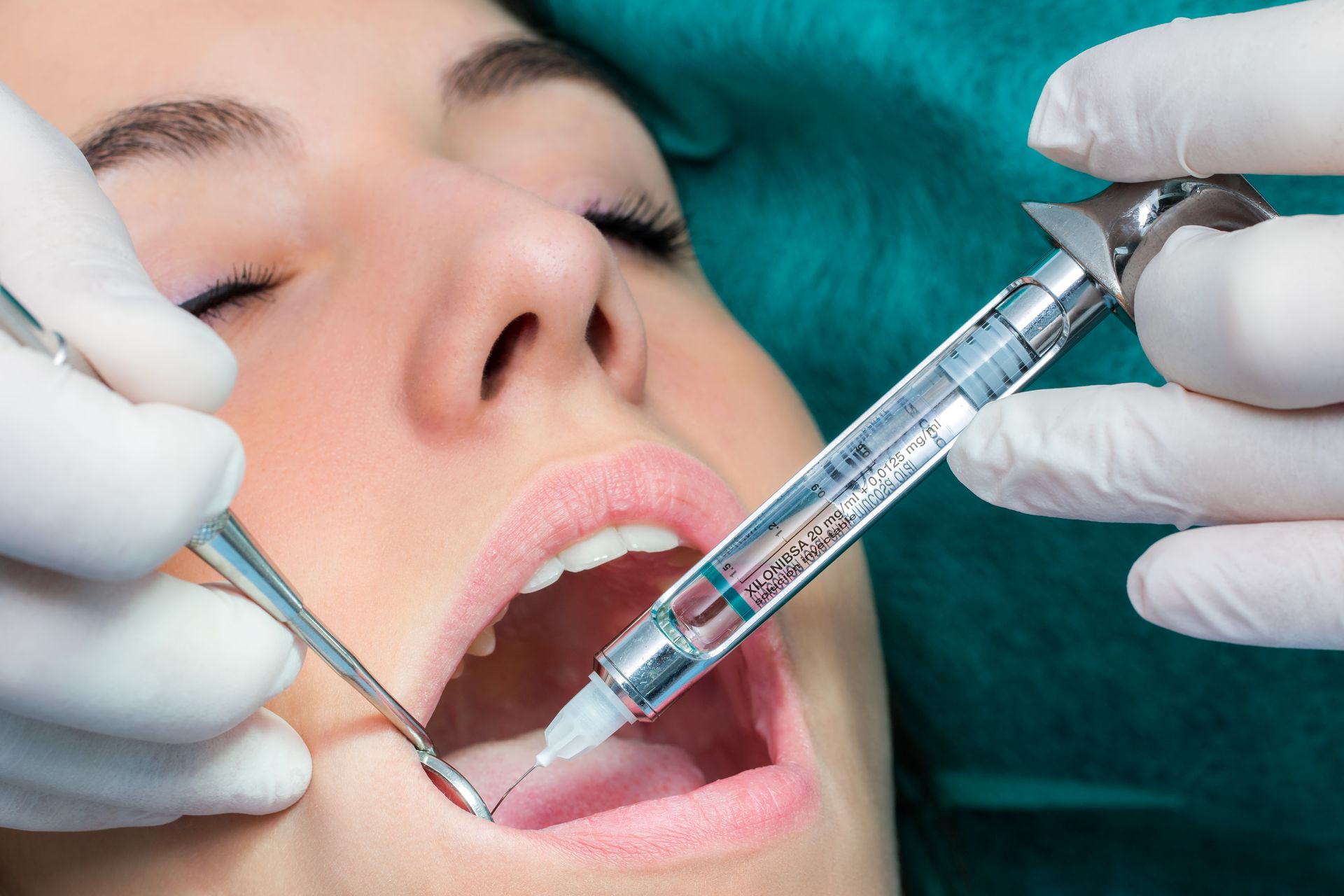 a woman getting her teeth checked by a dentist