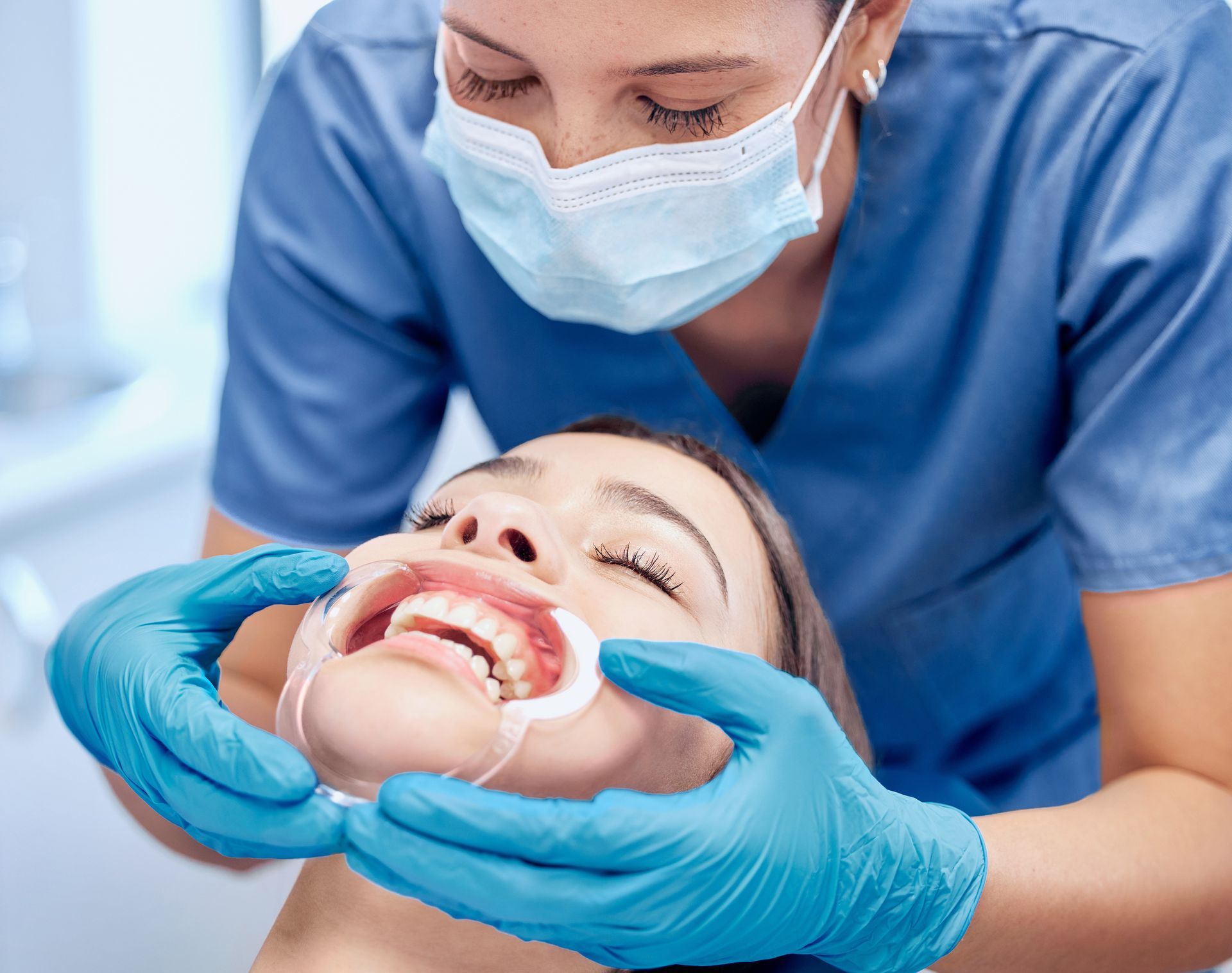 a woman getting her teeth checked by a dentist